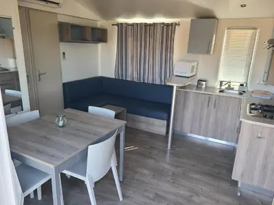 a kitchen and dining room with a table and chairs at Camping Nysa Paziols in Paziols