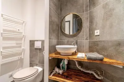 a bathroom with a sink and a toilet and a mirror at Le Cocon Coloré in Carcassonne