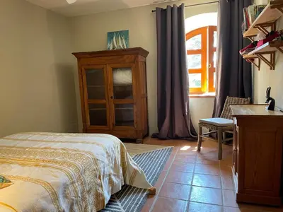 a bedroom with a bed and a dresser and a window at Mas Vigneron in Gruissan