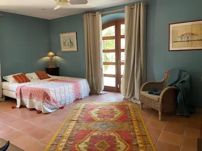 a bedroom with a bed and a window and a chair at Mas Vigneron in Gruissan