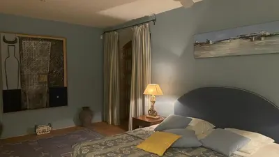 a bedroom with a bed and a lamp and a window at Mas Vigneron in Gruissan