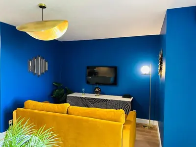 a living room with a yellow couch and blue walls at You&Me hyper centre ville avec draps serviettes ménage final in Narbonne