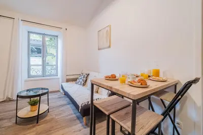 a living room with a table and a couch at La Petite Bastide in Carcassonne