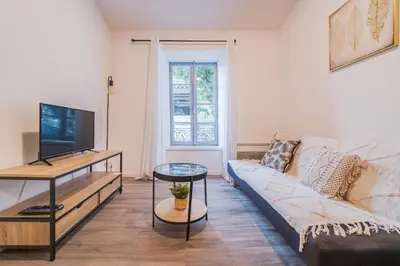 a living room with a couch and a tv at La Petite Bastide in Carcassonne