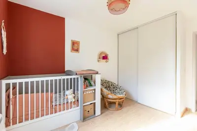 a nursery with a crib and a large sliding door at Villa t4 à la campagne in Belleserre