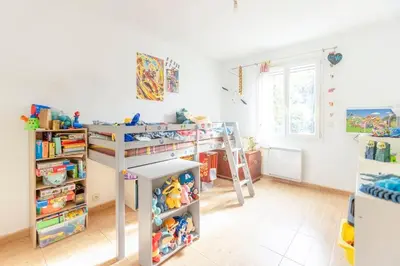 a childrens room with a bunk bed and shelves at Villa t4 à la campagne in Belleserre