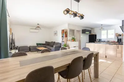 a kitchen and a living room with a table and chairs at Villa t4 à la campagne in Belleserre