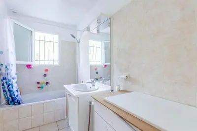 a bathroom with a tub and a sink and a bath tub at Villa t4 à la campagne in Belleserre
