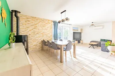 a dining room and living room with a table and chairs at Villa t4 à la campagne in Belleserre