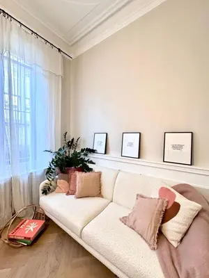 a living room with a white couch and a window at Appartement de luxe à deux pas des Halles, quai Valliere in Narbonne