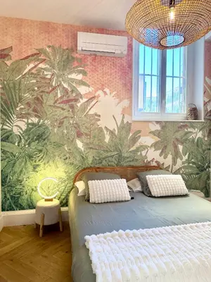 a bedroom with a bed with a mural of palm trees at Appartement de luxe à deux pas des Halles, quai Valliere in Narbonne