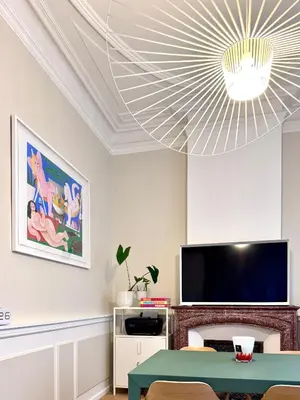 a living room with a table and a large chandelier at Appartement de luxe à deux pas des Halles, quai Valliere in Narbonne