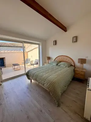 a bedroom with a bed and a large window at La Maison de Sainte-Eulalie in Roubia