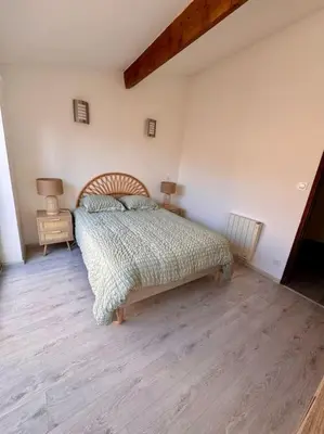 a bedroom with a bed and a wooden floor at La Maison de Sainte-Eulalie in Roubia