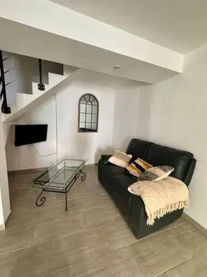 a living room with a black couch and a glass table at La Maison de Sainte-Eulalie in Roubia