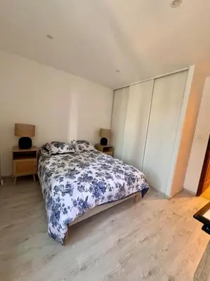 a bedroom with a bed with blue and white sheets at La Maison de Sainte-Eulalie in Roubia