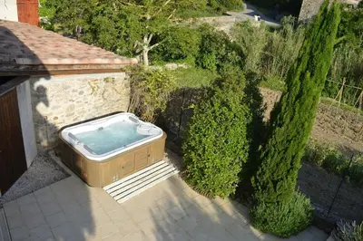a hot tub sitting on a patio next to some bushes at Luxury cottage with Jacuzzi in Saint-Polycarpe in Saint-Polycarpe
