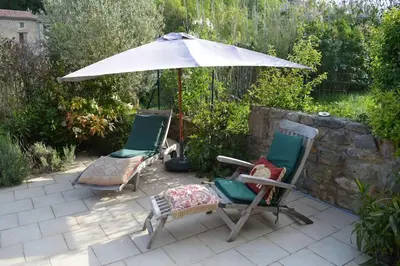 two chairs and an umbrella on a patio at Luxury cottage with Jacuzzi in Saint-Polycarpe in Saint-Polycarpe