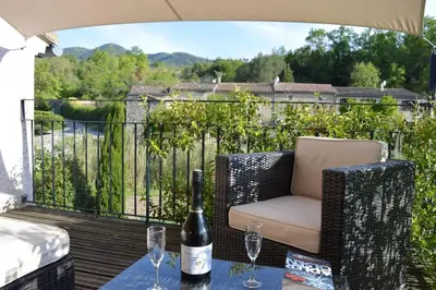 a bottle of wine and a chair on a deck at Luxury cottage with Jacuzzi in Saint-Polycarpe in Saint-Polycarpe