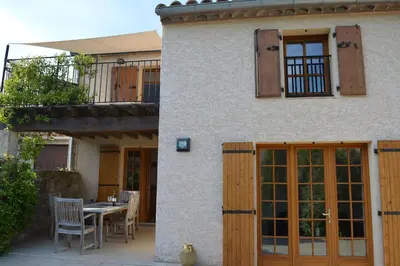 a house with a patio with a table and chairs at Luxury cottage with Jacuzzi in Saint-Polycarpe in Saint-Polycarpe