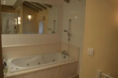 a bath tub in a bathroom with a large mirror at Luxury cottage with Jacuzzi in Saint-Polycarpe in Saint-Polycarpe