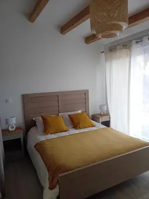 a bedroom with a large bed with yellow pillows at Le Grenadier in Ventenac-Cabardès