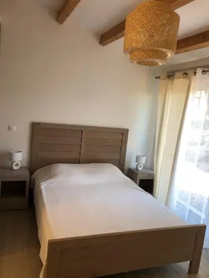 a bedroom with a large bed and a chandelier at Le Grenadier in Ventenac-Cabardès