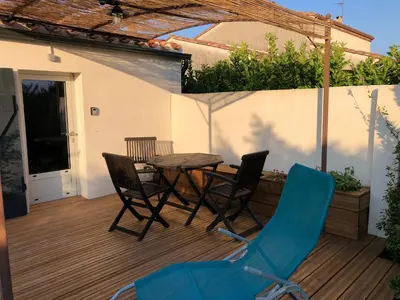 a patio with a table and chairs on a deck at Le Grenadier in Ventenac-Cabardès