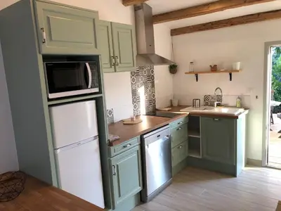 a kitchen with green cabinets and a microwave at Le Grenadier in Ventenac-Cabardès