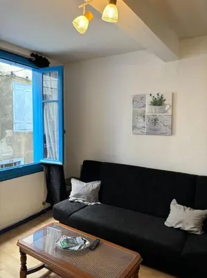 a living room with a black couch and a table at Central apartment in Quillan in Quillan