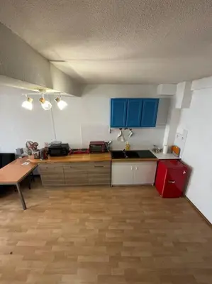 a kitchen with blue cabinets and a wooden floor at Central apartment in Quillan in Quillan