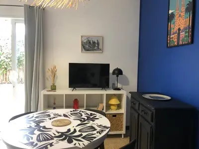a living room with a table and a tv at Ancienne maison de pêcheurs in Port-la-Nouvelle