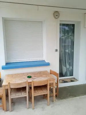 a wooden table and chairs in front of a window at Ancienne maison de pêcheurs in Port-la-Nouvelle