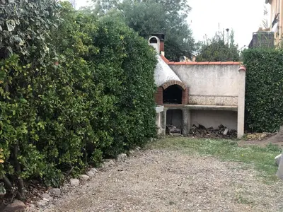 a house with a large hedge next to a building at Ancienne maison de pêcheurs in Port-la-Nouvelle