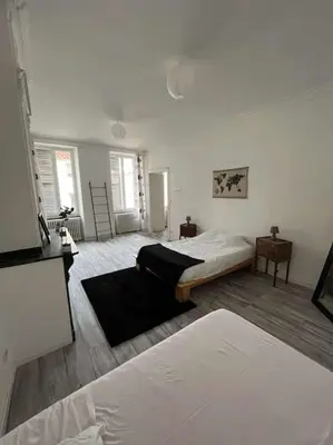 a white room with a bed and a room with a bed sqor at Appartement in Limoux