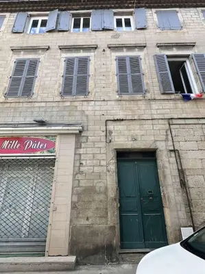 a brick building with a green door and windows at Appartement in Limoux