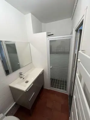 a white bathroom with a sink and a shower at Appartement in Limoux