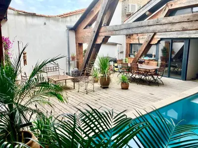 an outdoor deck with chairs and tables and plants at Vignerone atypique proche du canal du midi à 30 min des plages in Capestang