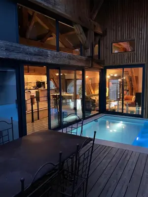a swimming pool in a house with a table and chairs at Vignerone atypique proche du canal du midi à 30 min des plages in Capestang