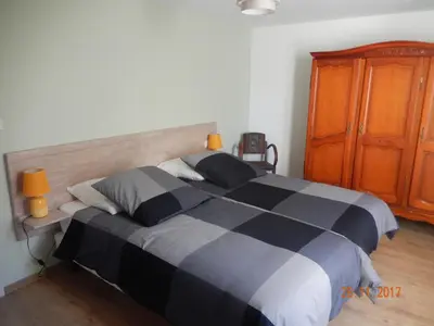 a bedroom with a black and white bed and a wooden cabinet at GITE Le calme de la campagne plus le confort in Viviès