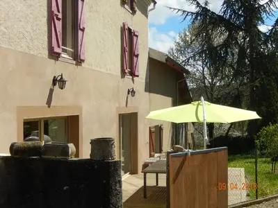 a yellow umbrella sitting outside of a building at GITE Le calme de la campagne plus le confort in Viviès