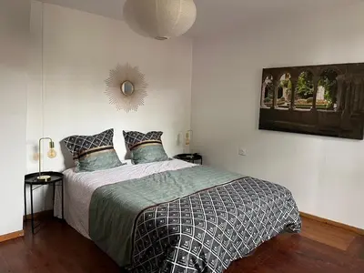 a bedroom with a bed and a picture on the wall at La maison du pont vieux - emplacement de parking gratuit - Proche Cité médiévale in Carcassonne