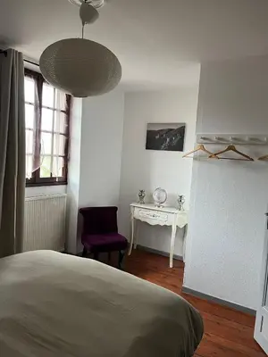 a bedroom with a bed and a table and a chair at La maison du pont vieux - emplacement de parking gratuit - Proche Cité médiévale in Carcassonne
