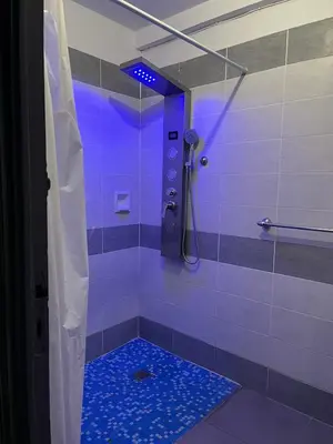 a bathroom with a shower with a blue light at La maison du pont vieux - emplacement de parking gratuit - Proche Cité médiévale in Carcassonne