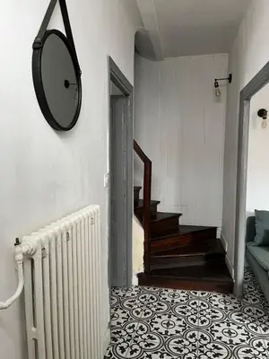 a hallway with a mirror on the wall and a staircase at La maison du pont vieux - emplacement de parking gratuit - Proche Cité médiévale in Carcassonne
