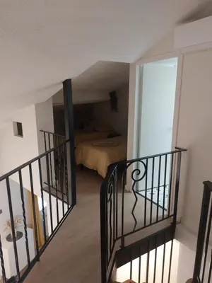 a staircase leading to a room with a bed at Appartement proche des Halles in Narbonne
