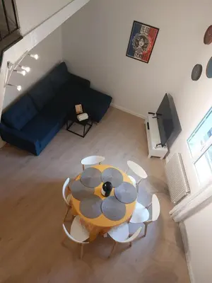 a table and chairs in a living room with a couch at Appartement proche des Halles in Narbonne