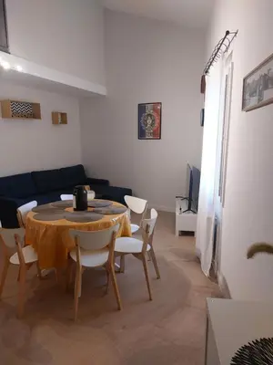 a living room with a table and chairs and a couch at Appartement proche des Halles in Narbonne
