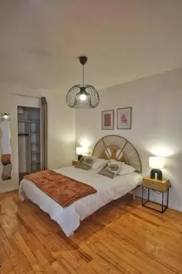 a bedroom with a large bed and a chandelier at Loft de caractère centre-ville in Narbonne