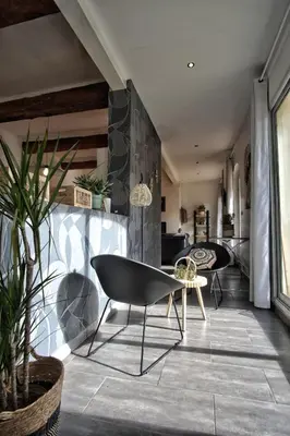 a living room with a chair and a table at Loft de caractère centre-ville in Narbonne